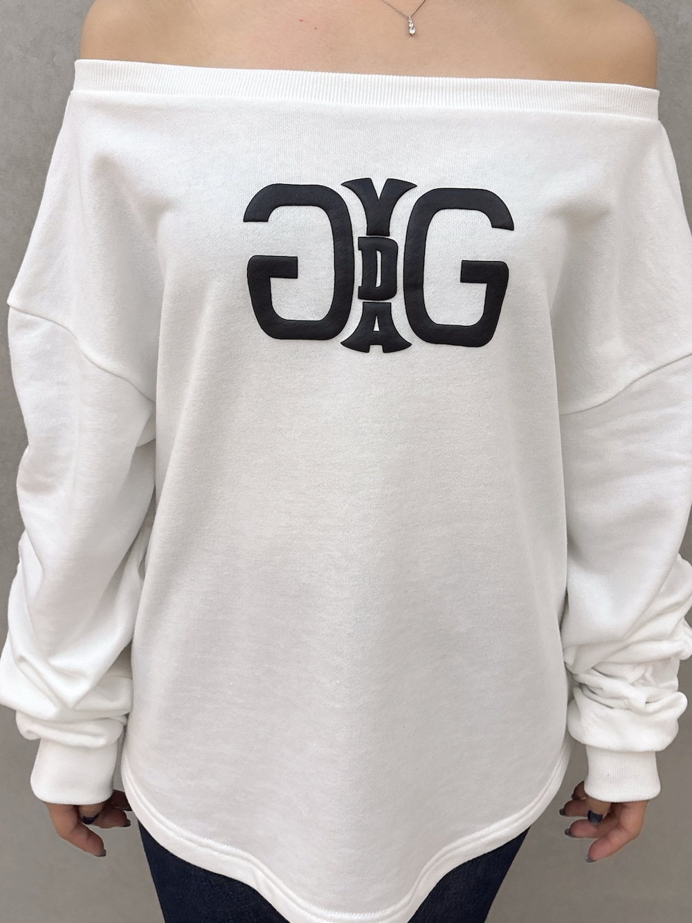 ホワイト系のスウェット、ブルー系のデニムパンツ、ブラック系のブーツを着用したレディースの秋コーディネートの5枚目の写真