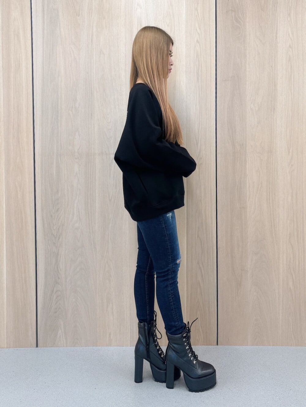 ブルー系のデニムパンツ、ブラック系のブーツ、ブラック系のスウェットを着用したレディースの春コーディネートの2枚目の写真