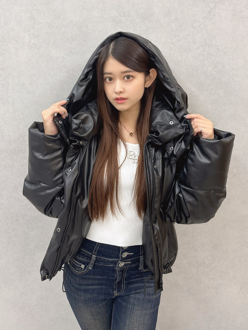 ホワイト系のニット/セーター、ブラック系のダウンジャケット/コート、ブラック系のブーツを着用したレディースの秋コーディネートの5枚目の写真