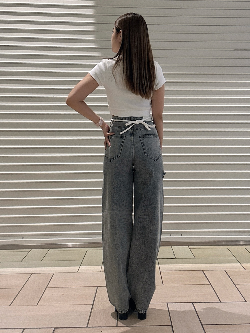 ホワイト系のTシャツ/カットソー、ブルー系のデニムパンツ、ブラック系のサンダルを着用したレディースの春コーディネートの3枚目の写真
