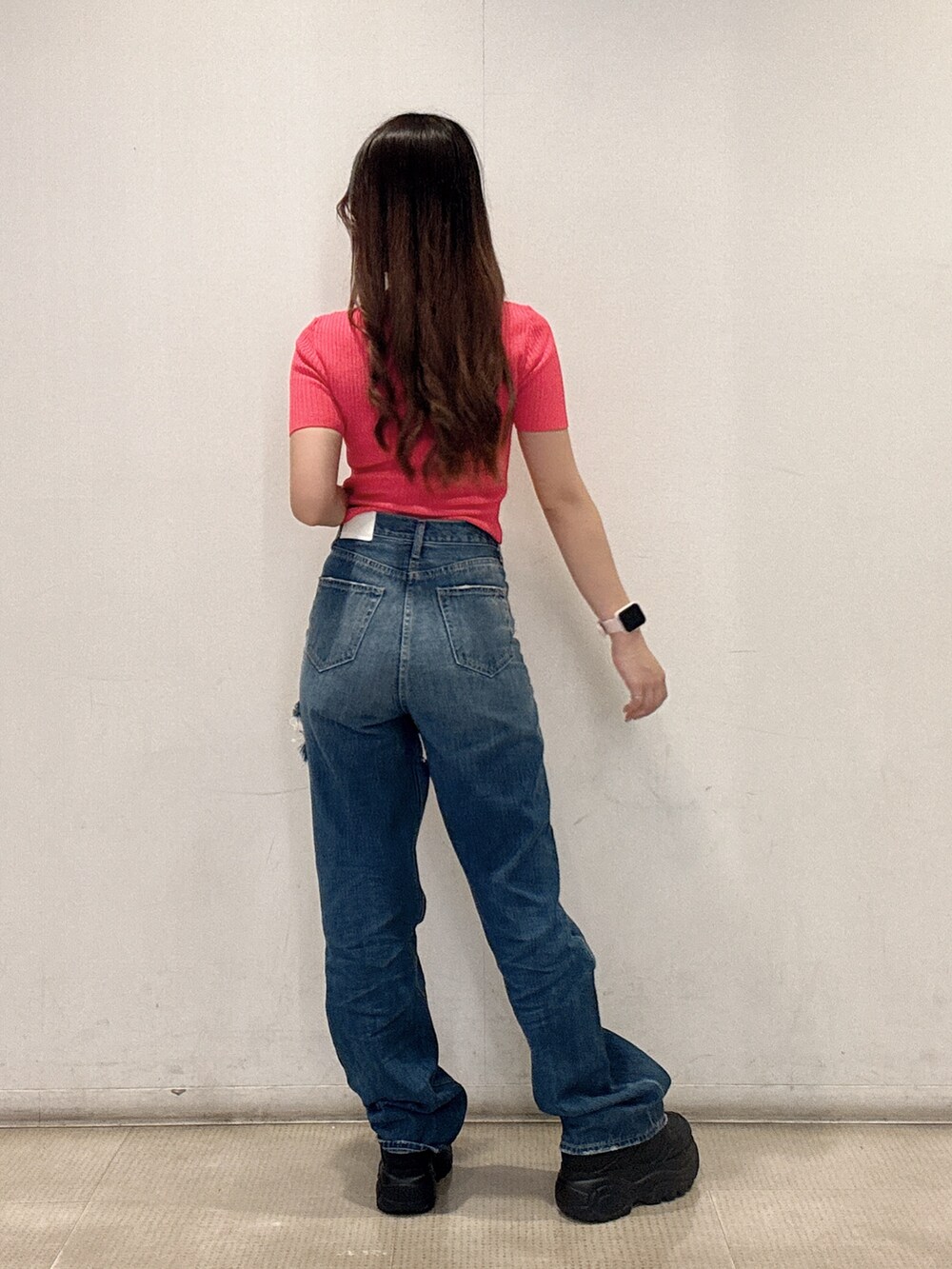 ピンク系のニット/セーター、ブルー系のデニムパンツ、ブラック系のスニーカーを着用したレディースの春コーディネートの3枚目の写真