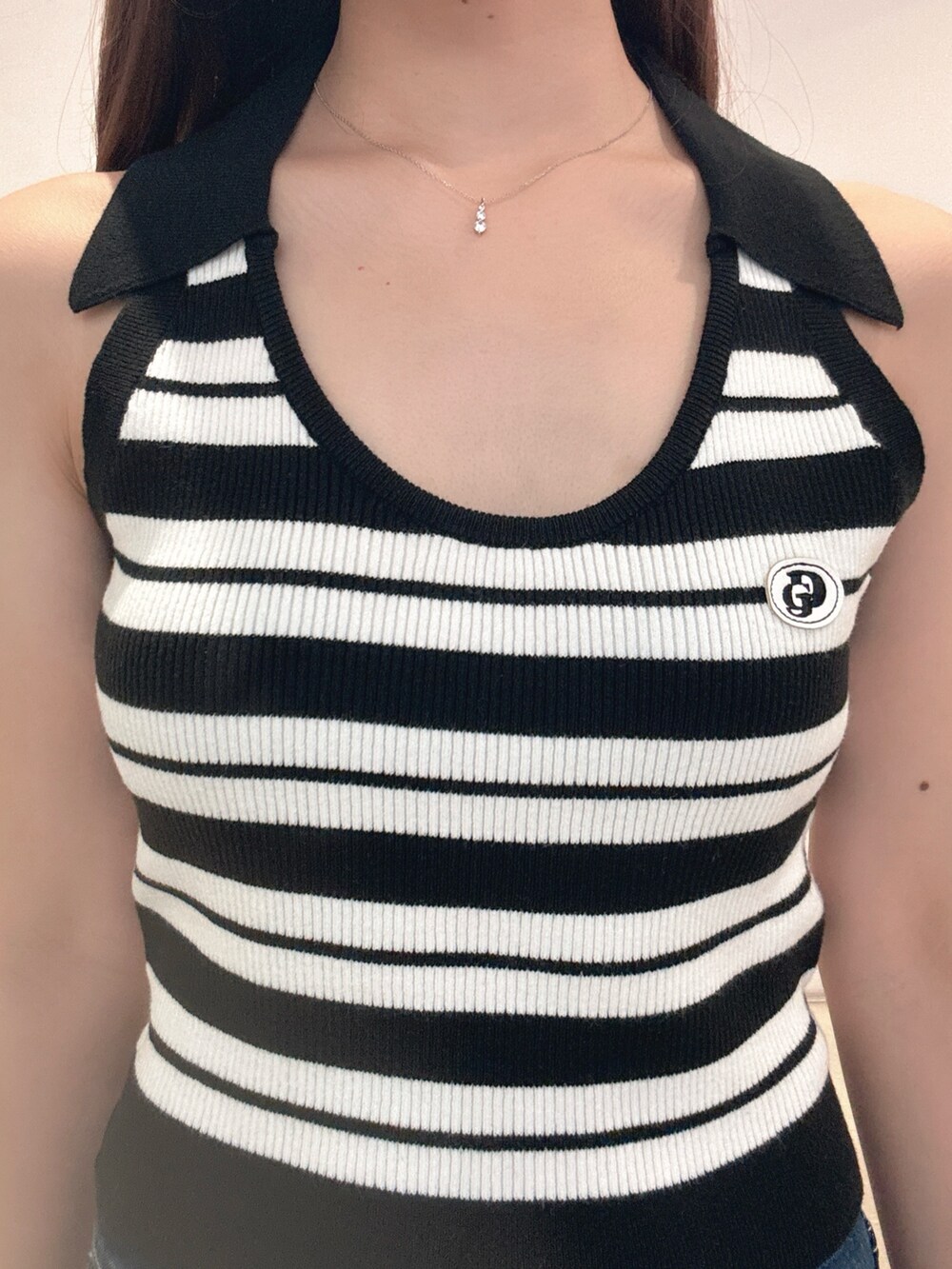 ホワイト系のニット/セーター、ブルー系のデニムパンツ、ブラック系のパンプスを着用したレディースの春コーディネートの5枚目の写真