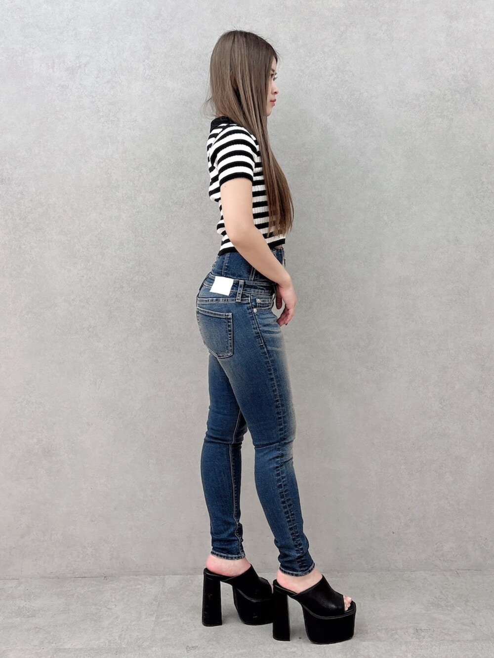 ブルー系のデニムパンツ、ブラック系のサンダル、その他のニット/セーターを着用したレディースの春コーディネートの2枚目の写真