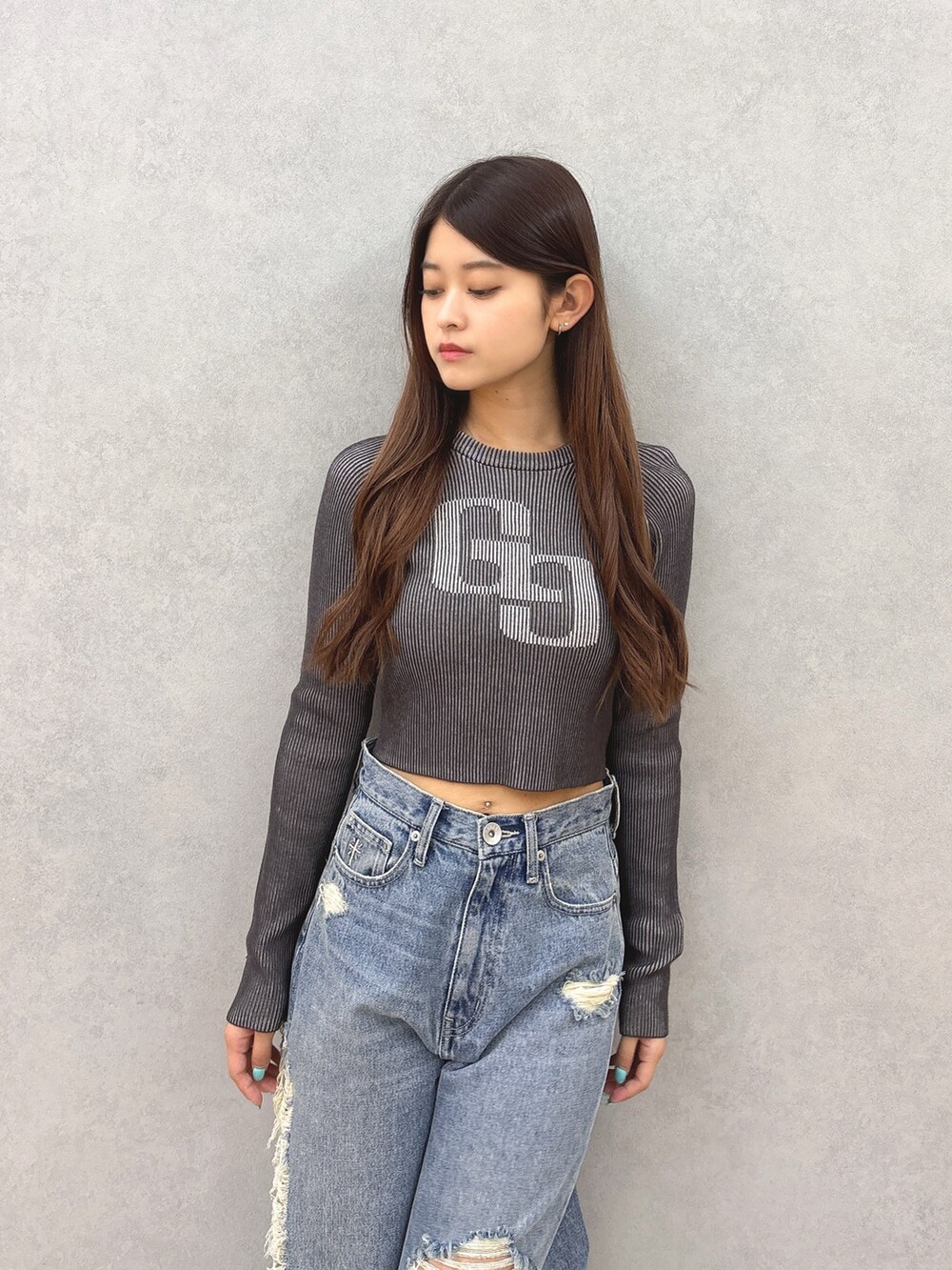 ブラック系のニット/セーター、ブルー系のデニムパンツ、ブラック系のサンダルを着用したレディースの夏コーディネートの4枚目の写真