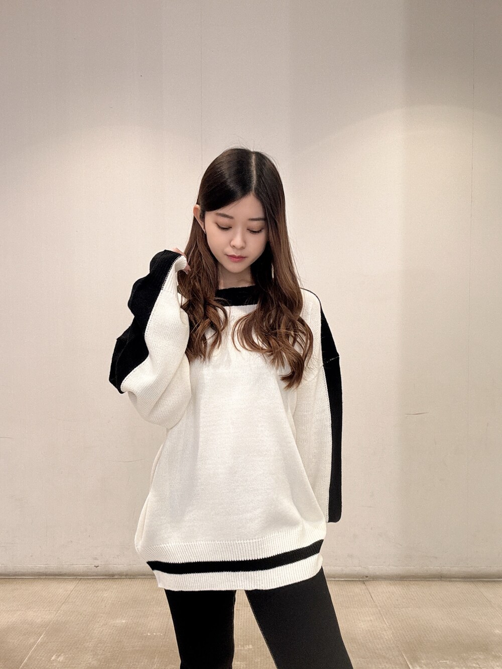 ホワイト系のニット/セーター、ブラック系のデニムパンツ、ブラック系のパンプスを着用したレディースの春コーディネートの5枚目の写真