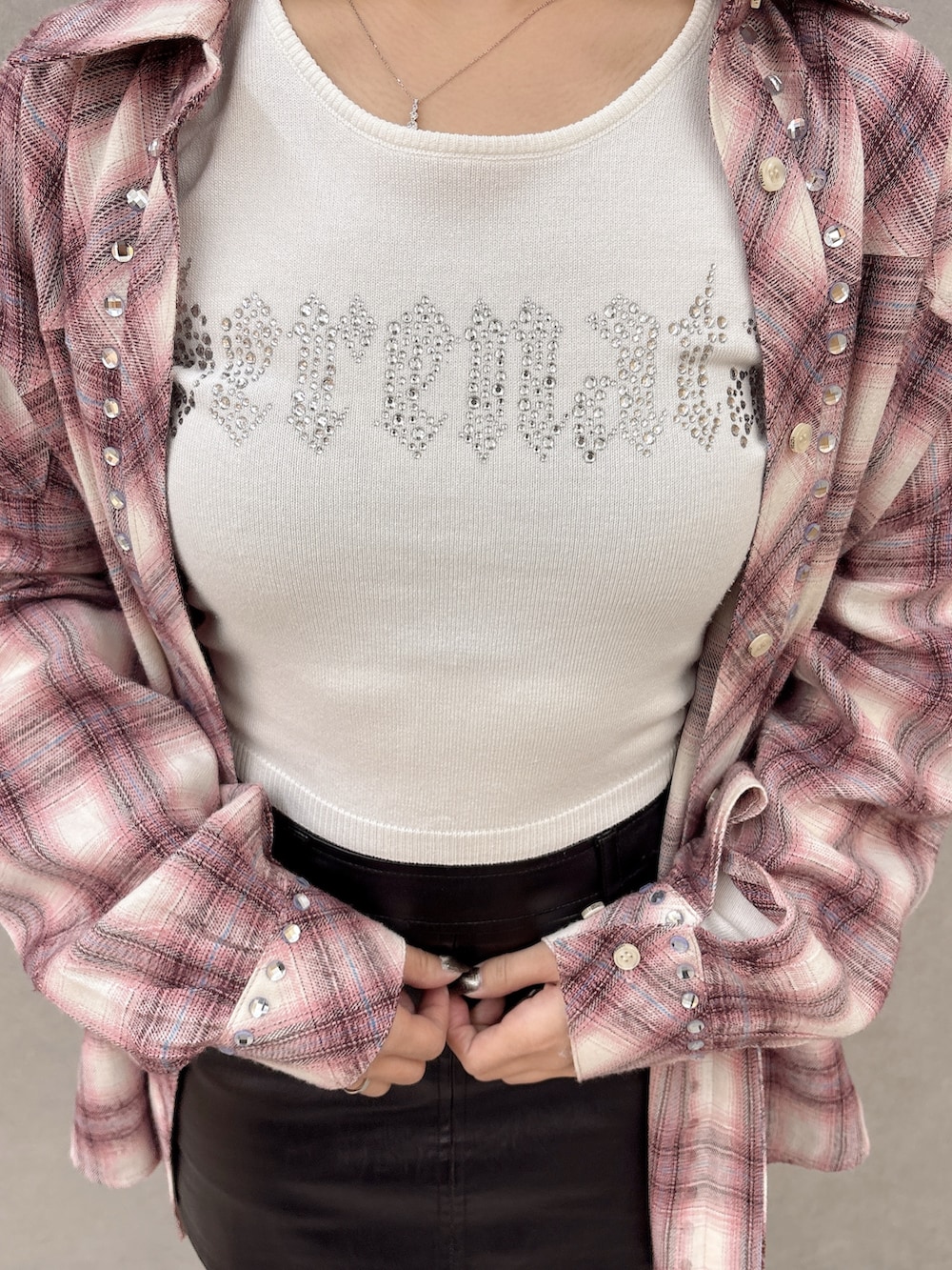 ホワイト系のニット/セーター、ピンク系のシャツ/ブラウス、ブラック系のスカートを着用したレディースの冬コーディネートの6枚目の写真