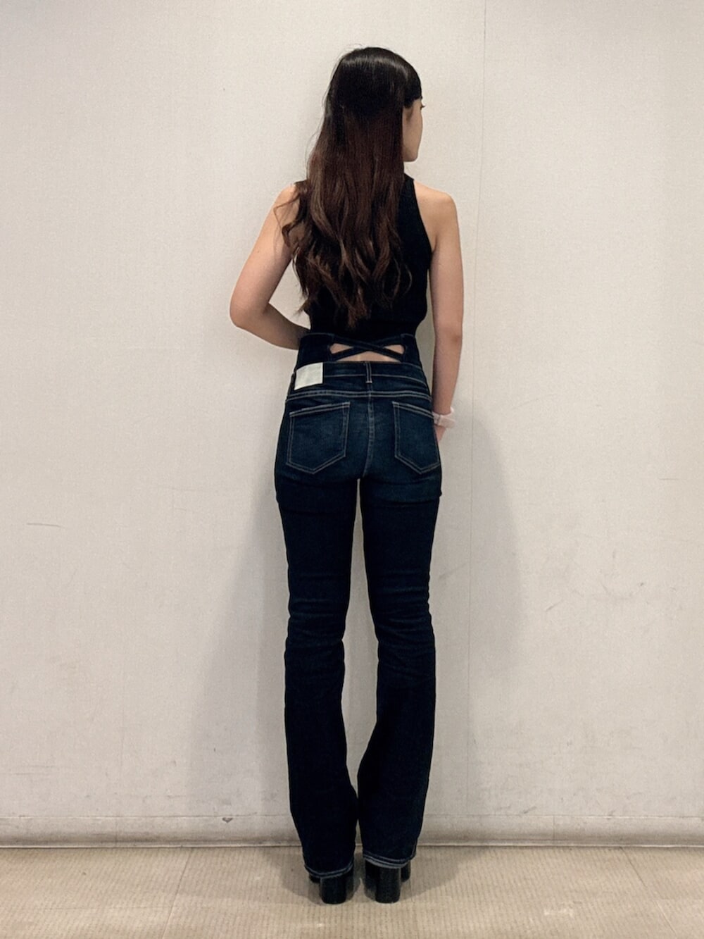 ブラック系のサンダル、ブラック系のニット/セーター、ブルー系のデニムパンツを着用したレディースの夏コーディネートの3枚目の写真