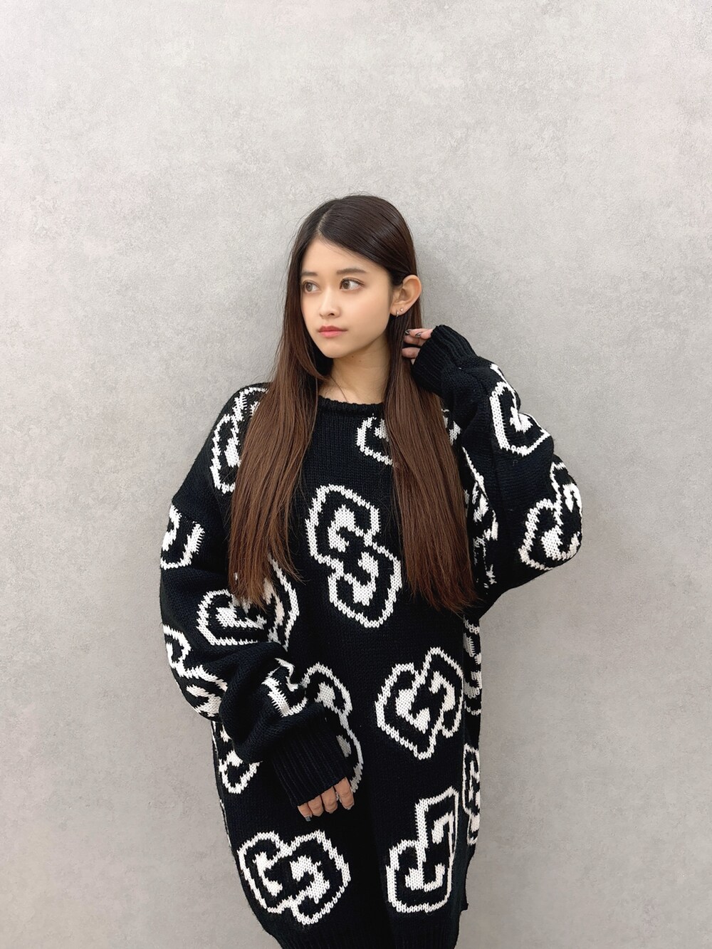 ブラック系のニット/セーター、ブルー系のデニムパンツ、ブラック系のブーツを着用したレディースの秋コーディネートの4枚目の写真
