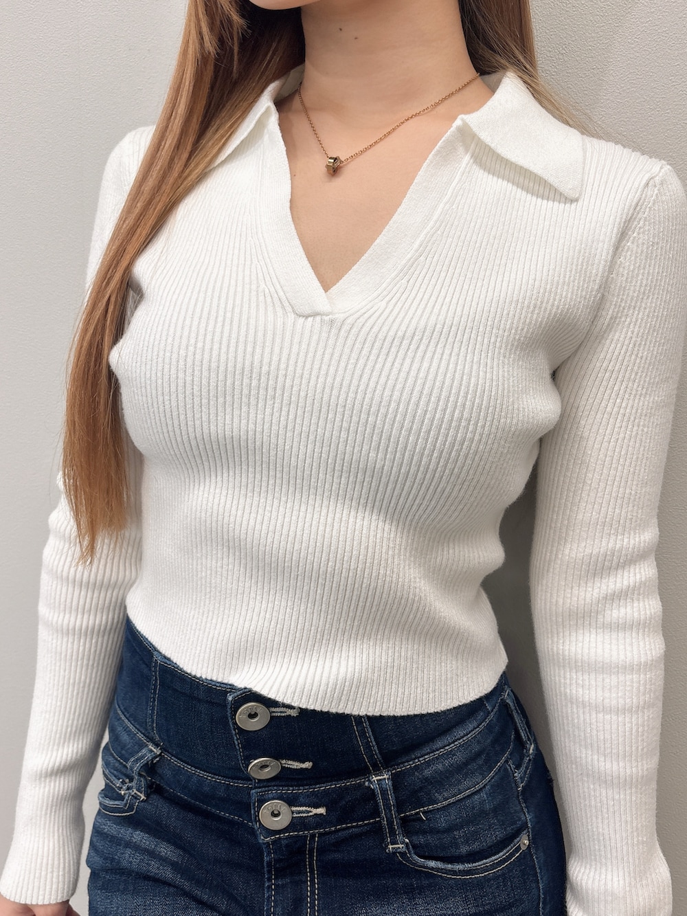 ホワイト系のニット/セーター、ブルー系のデニムパンツ、ブラック系のブーツを着用したレディースの春コーディネートの5枚目の写真