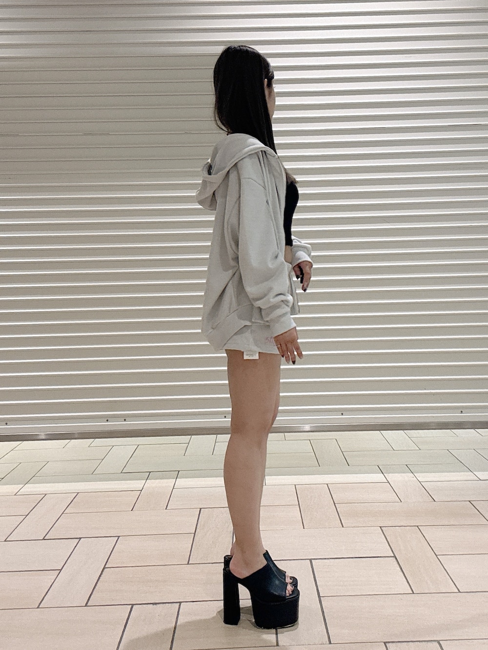 ブラック系のキャミソール、ホワイト系のパーカー、ホワイト系のその他パンツを着用したレディースの夏コーディネートの2枚目の写真