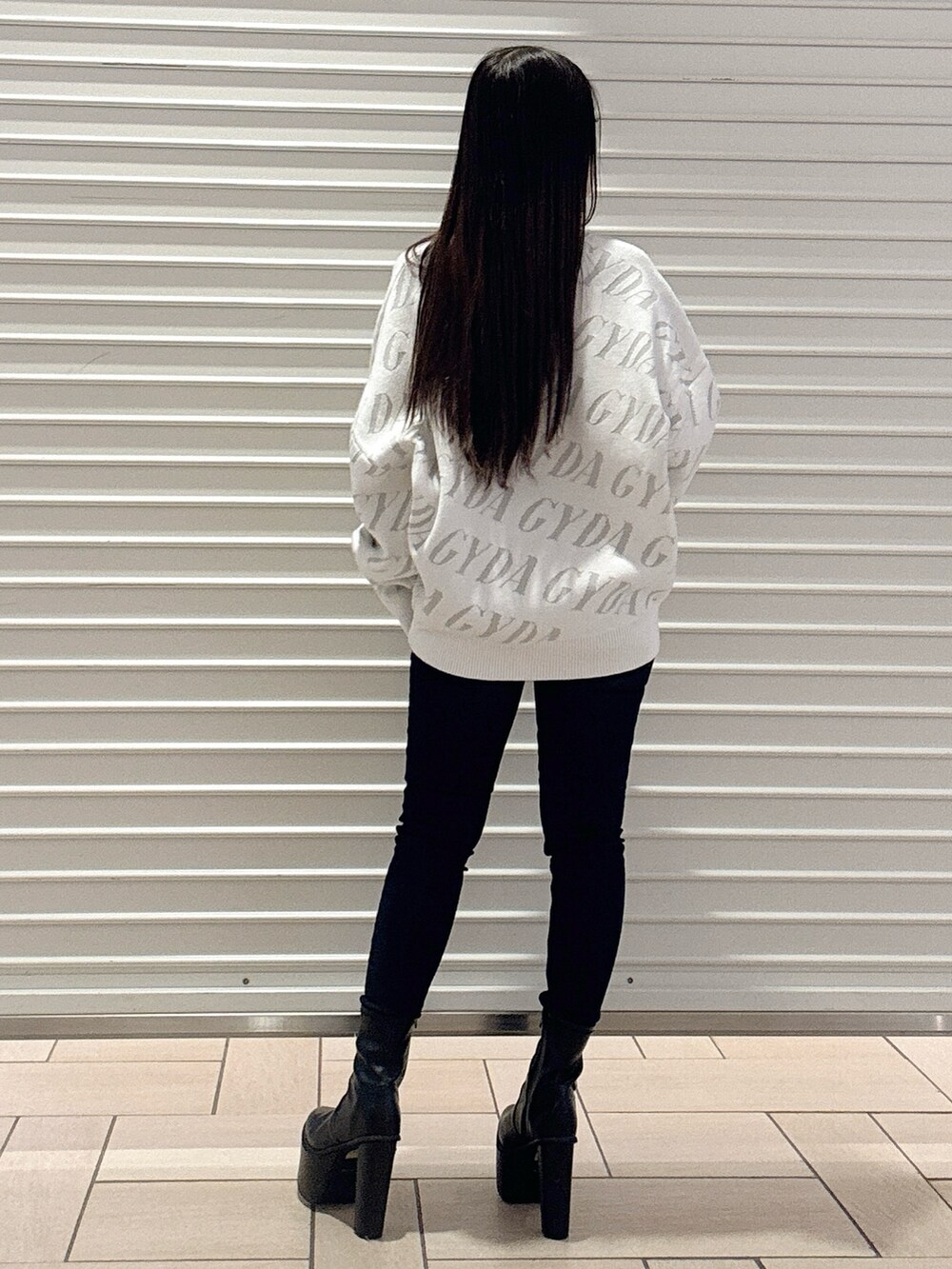 ホワイト系のニット/セーター、ブルー系のデニムパンツ、ブラック系のブーツを着用したレディースの秋コーディネートの4枚目の写真