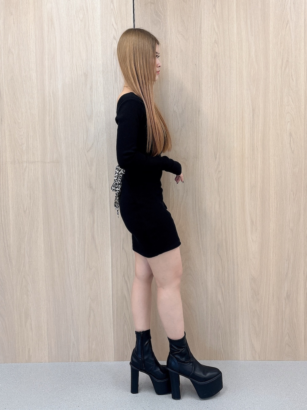 ブラック系のワンピース、ブラック系のブーツを着用したレディースの春コーディネートの2枚目の写真