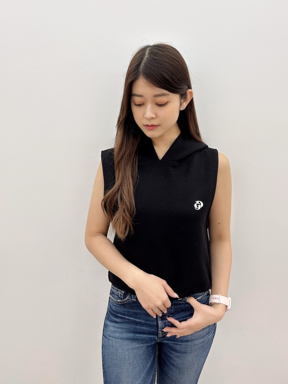 ブラック系のパーカー、ブルー系のデニムパンツ、ベージュ系のサンダルを着用したレディースの夏コーディネートの4枚目の写真