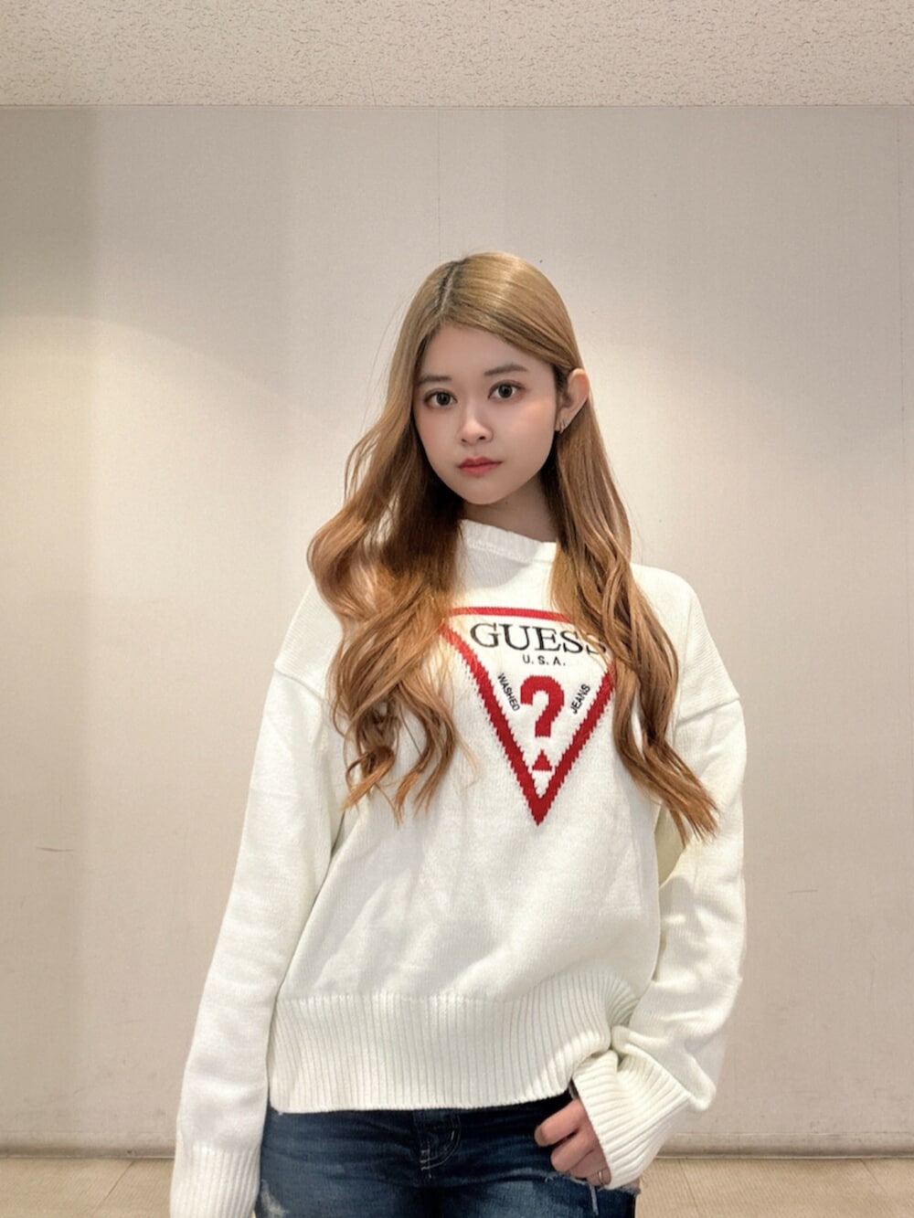 ブラック系のブーツ、ブルー系のデニムパンツ、ホワイト系のニット/セーターを着用したレディースの春コーディネートの4枚目の写真