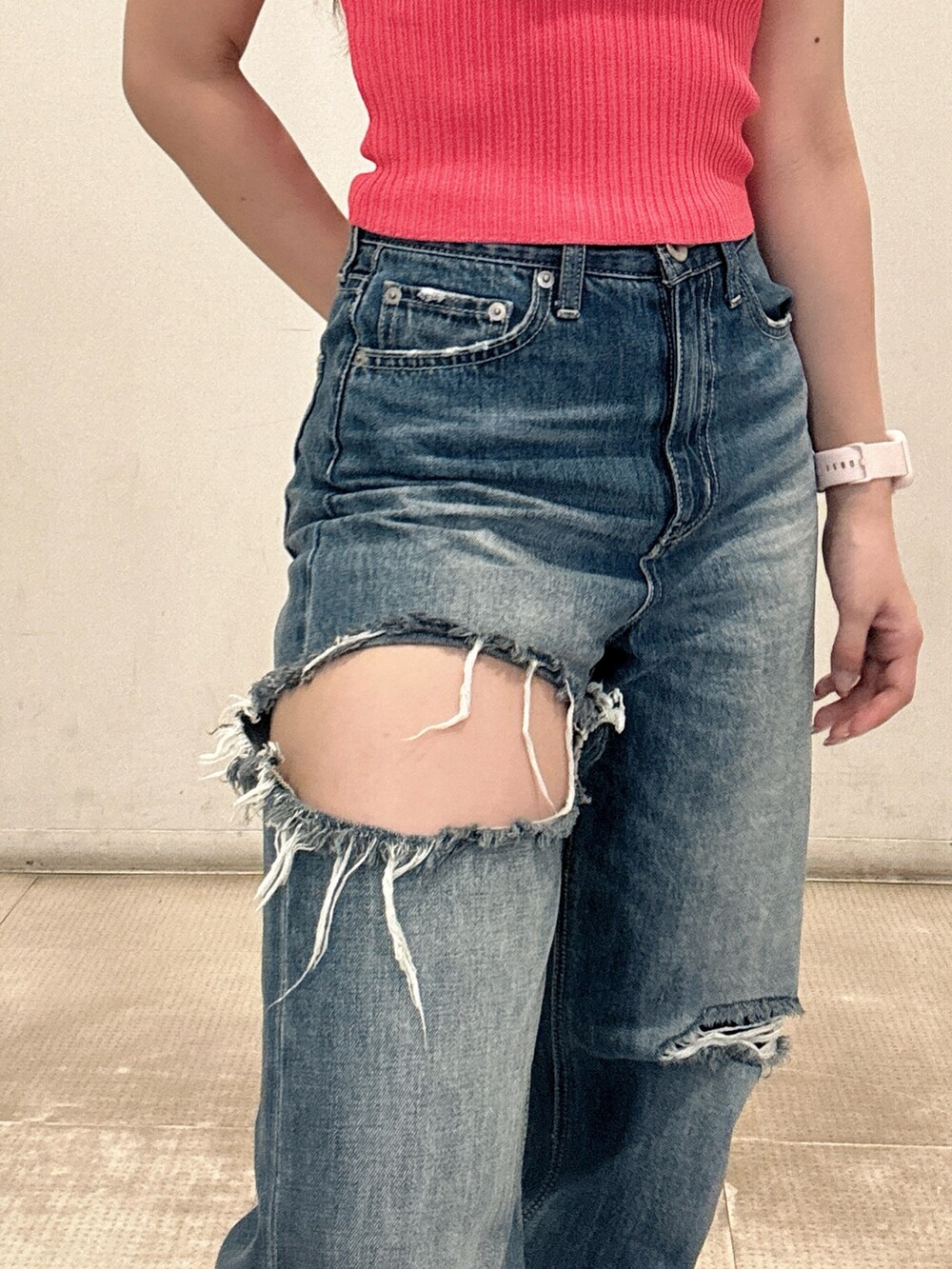 ピンク系のニット/セーター、ブルー系のデニムパンツ、ブラック系のスニーカーを着用したレディースの春コーディネートの6枚目の写真