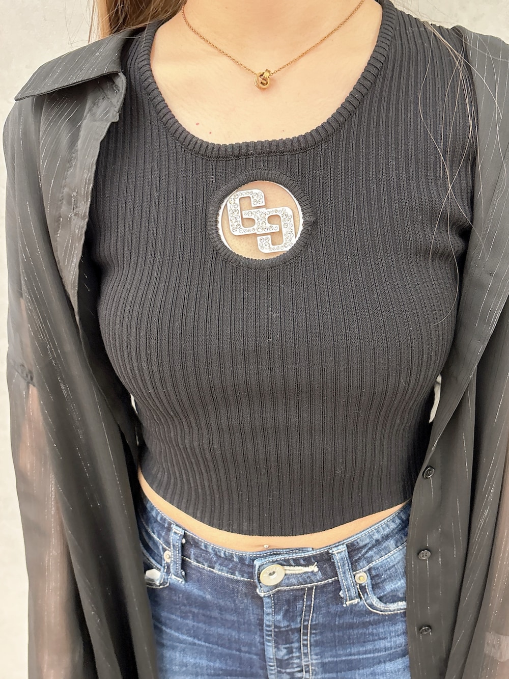 ブラック系のシャツ/ブラウス、ブラック系のTシャツ/カットソー、ブルー系のデニムパンツを着用したレディースの冬コーディネートの5枚目の写真