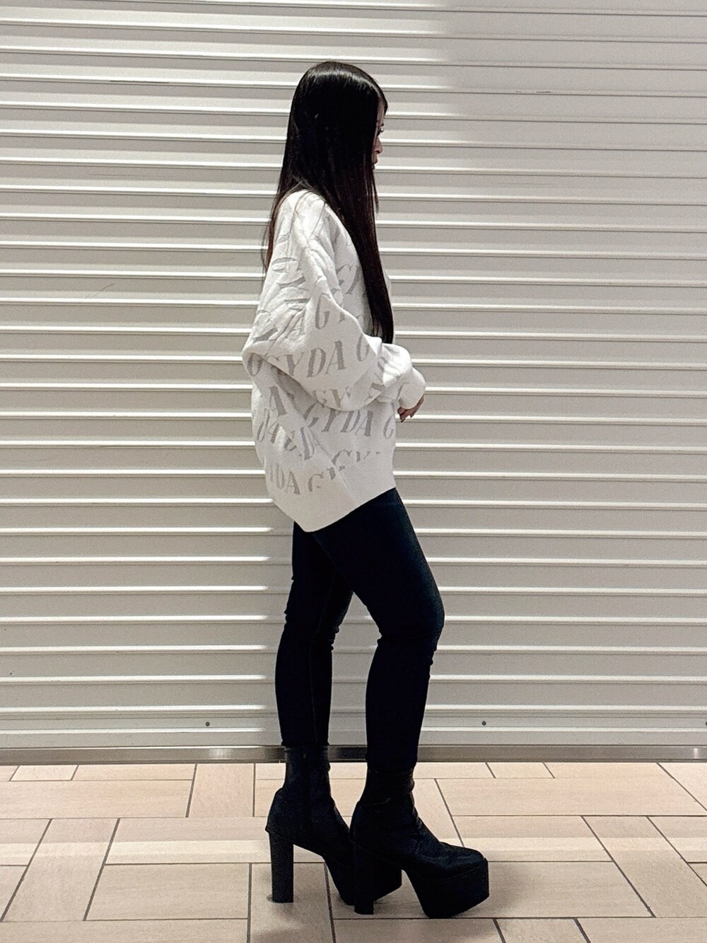 ホワイト系のニット/セーター、ブルー系のデニムパンツ、ブラック系のブーツを着用したレディースの秋コーディネートの3枚目の写真