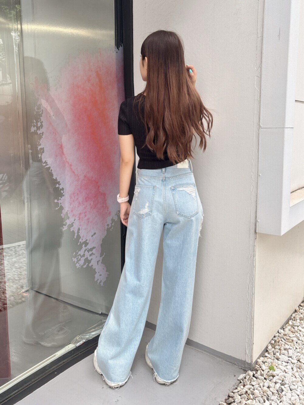 ホワイト系のサンダル、ブルー系のデニムパンツ、ブラック系のニット/セーターを着用したレディースの夏コーディネートの3枚目の写真