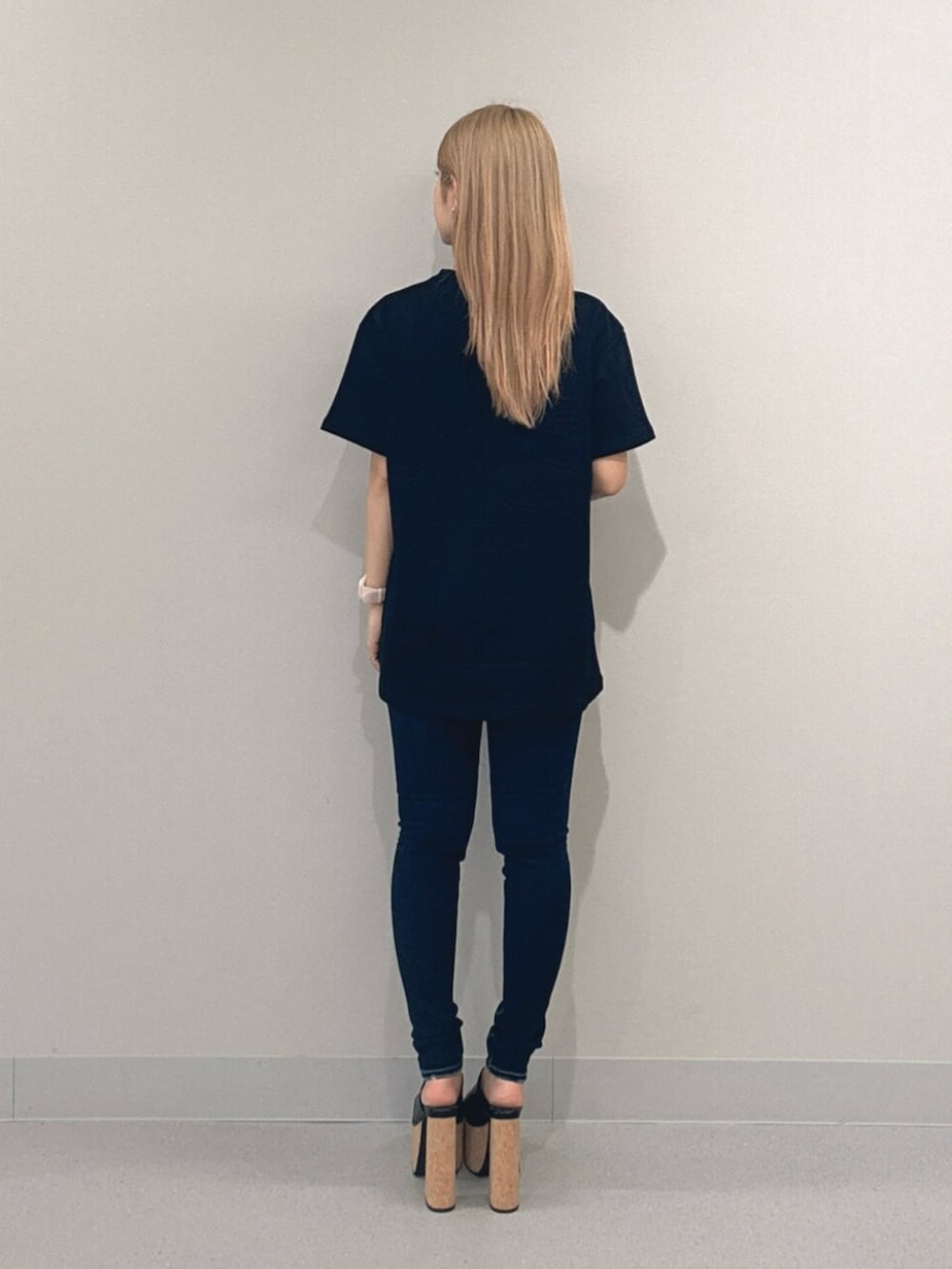 ブルー系のデニムパンツ、ブラック系のサンダル、ブラック系のTシャツ/カットソーを着用したレディースの夏コーディネートの3枚目の写真