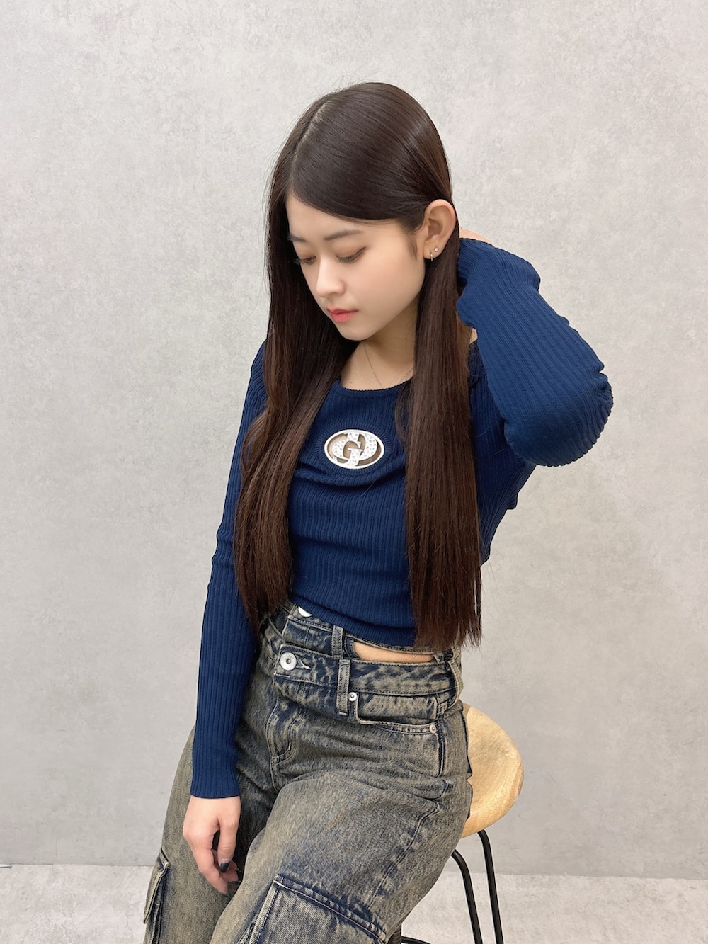 ブルー系のニット/セーター、ブルー系のデニムパンツ、ブラック系のスニーカーを着用したレディースの秋コーディネートの5枚目の写真