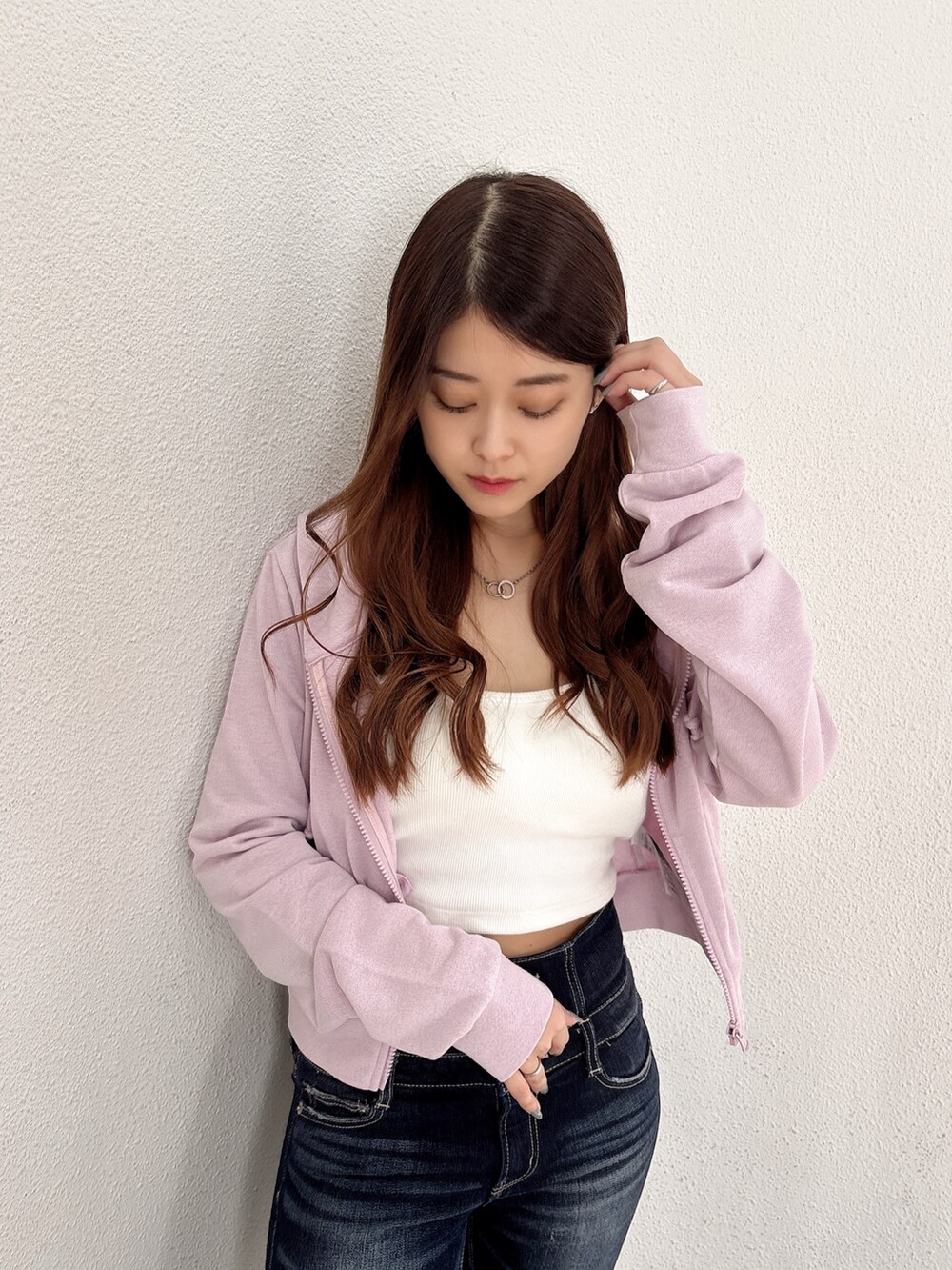 ホワイト系のキャミソール、パープル系のパーカー、ブルー系のデニムパンツを着用したレディースの春コーディネートの4枚目の写真