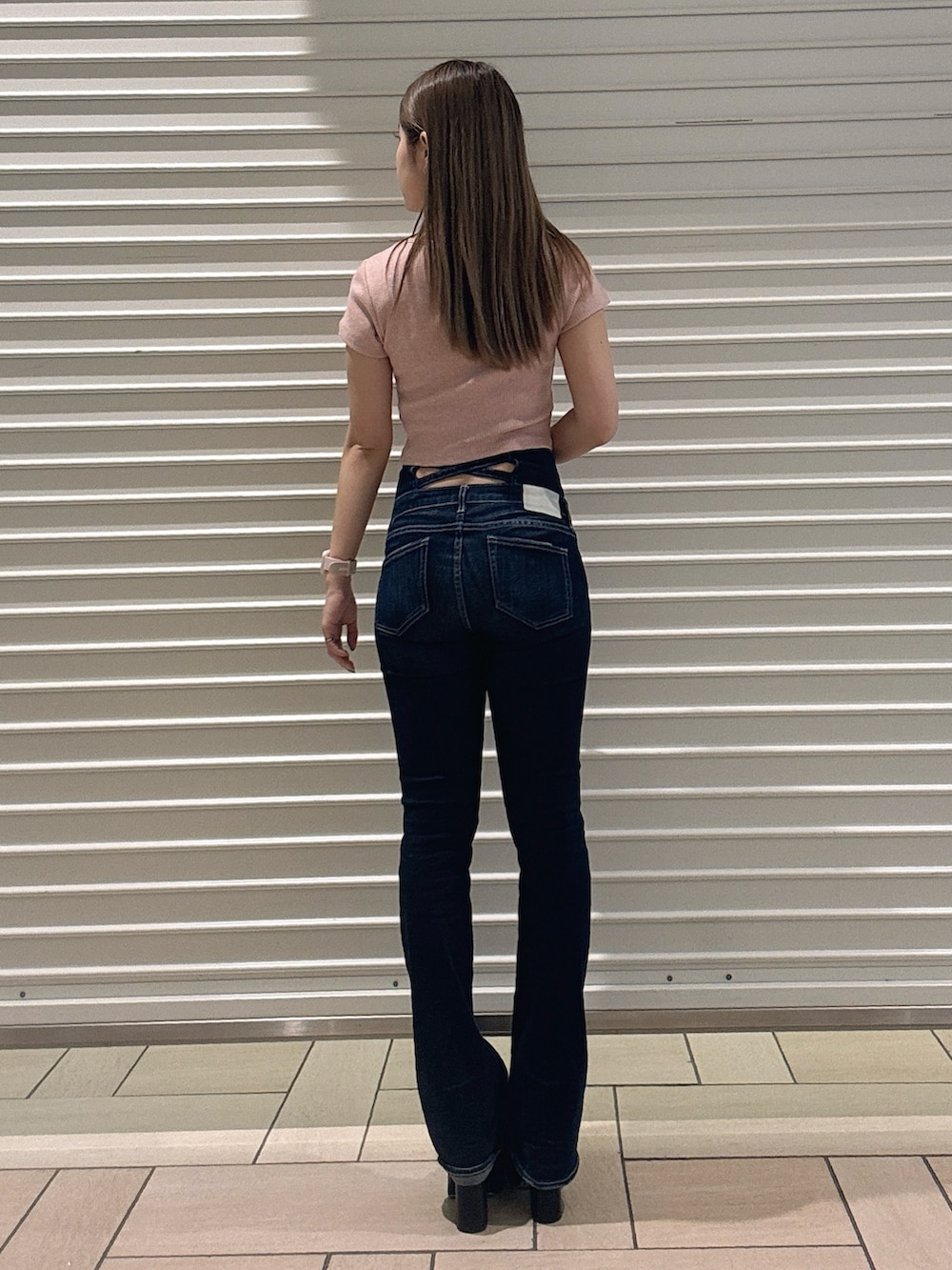 ピンク系のTシャツ/カットソー、ブルー系のデニムパンツ、ブラック系のサンダルを着用したレディースの春コーディネートの3枚目の写真