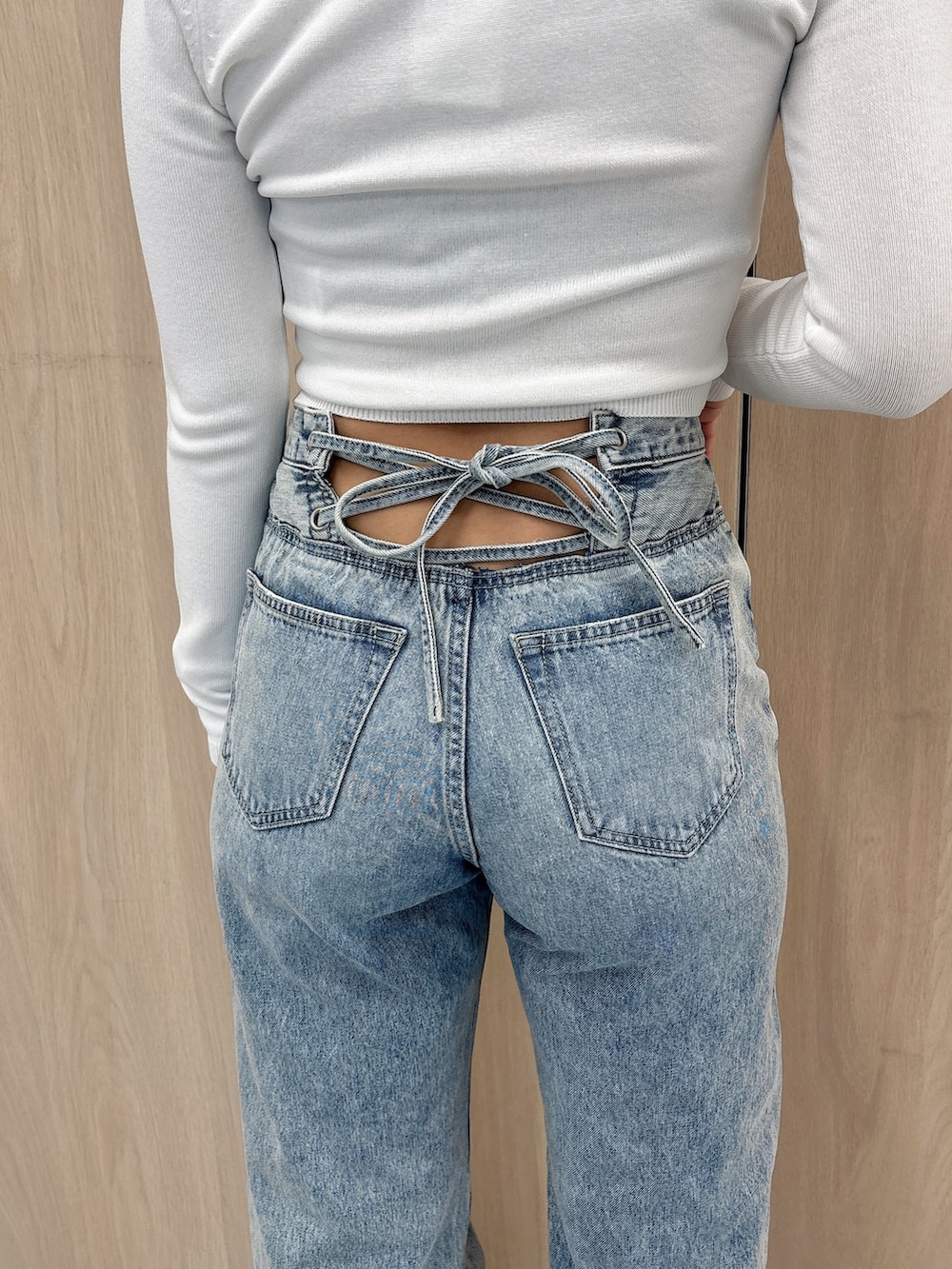 ホワイト系のニット/セーター、ブルー系のデニムパンツ、ブラック系のブーツを着用したレディースの春コーディネートの6枚目の写真