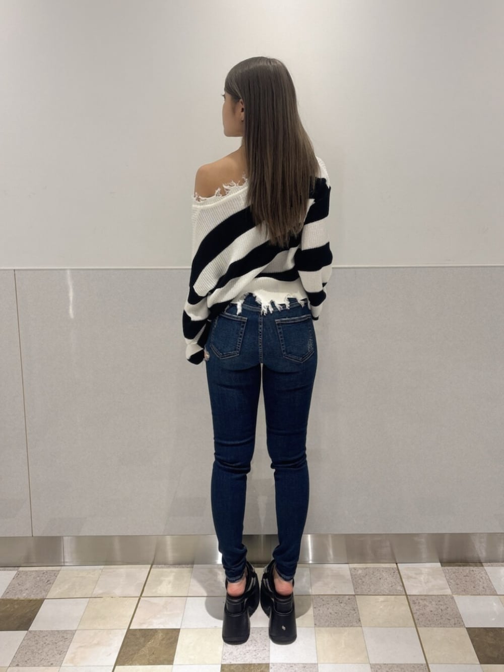 ブラック系のサンダル、ブルー系のデニムパンツ、ブラック系のニット/セーターを着用したレディースの夏コーディネートの3枚目の写真
