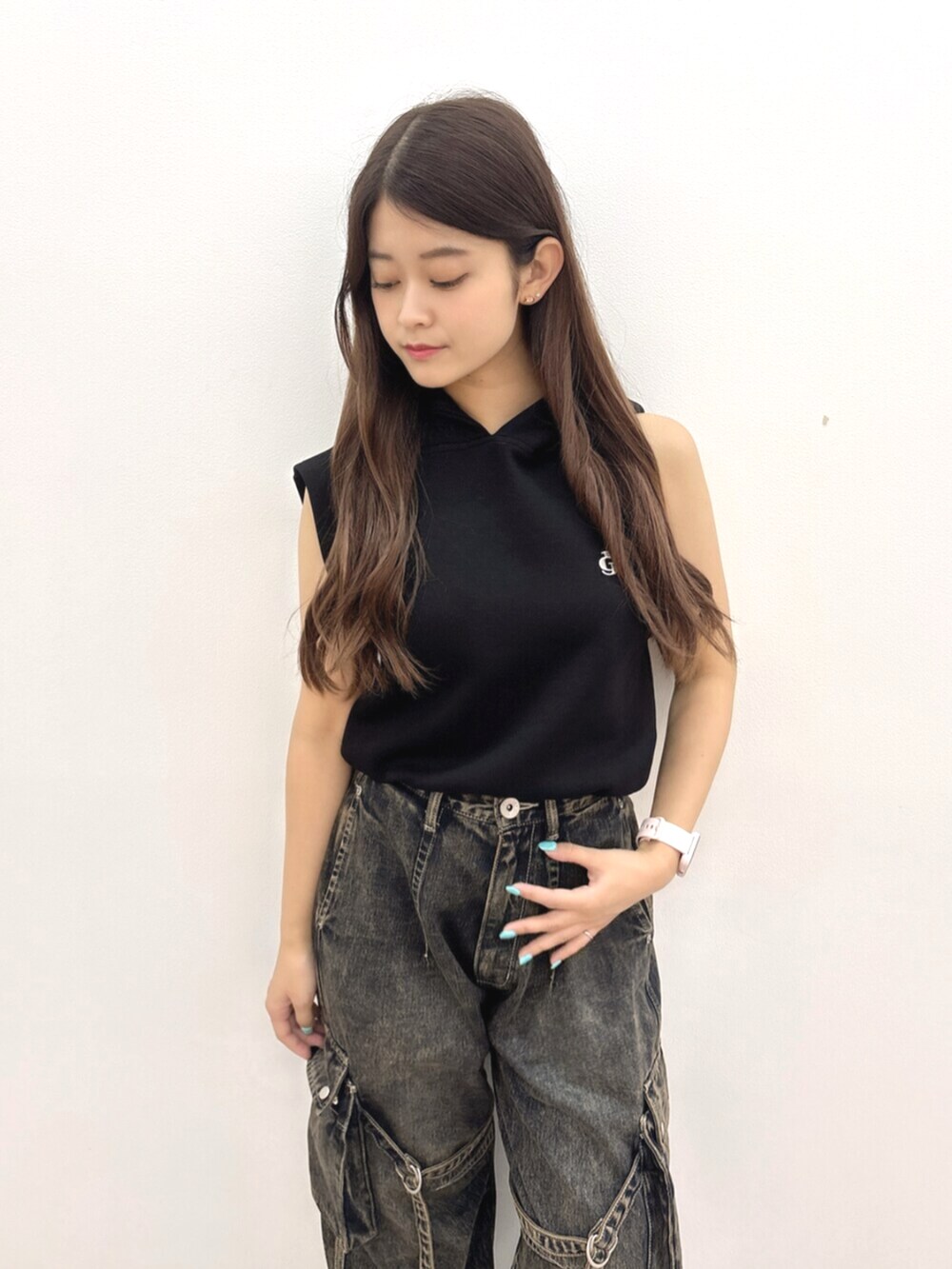 ブラック系のパーカー、ブルー系のデニムパンツ、ブラック系のサンダルを着用したレディースの夏コーディネートの4枚目の写真