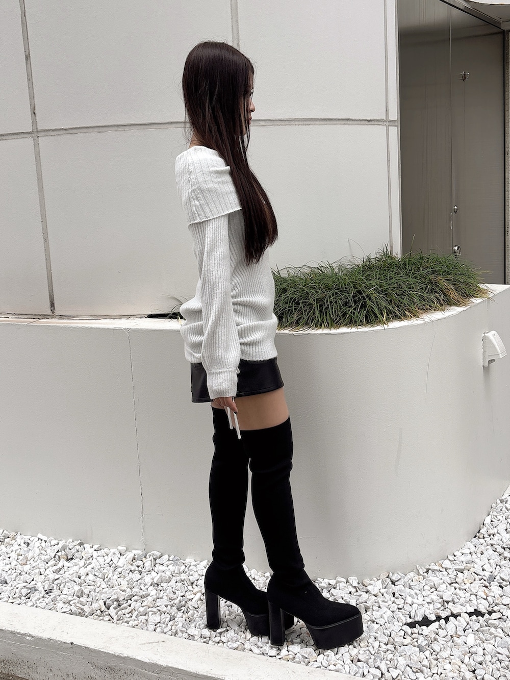 ホワイト系のチュニック、ブラック系のスカート、ブラック系のブーツを着用したレディースの秋コーディネートの3枚目の写真