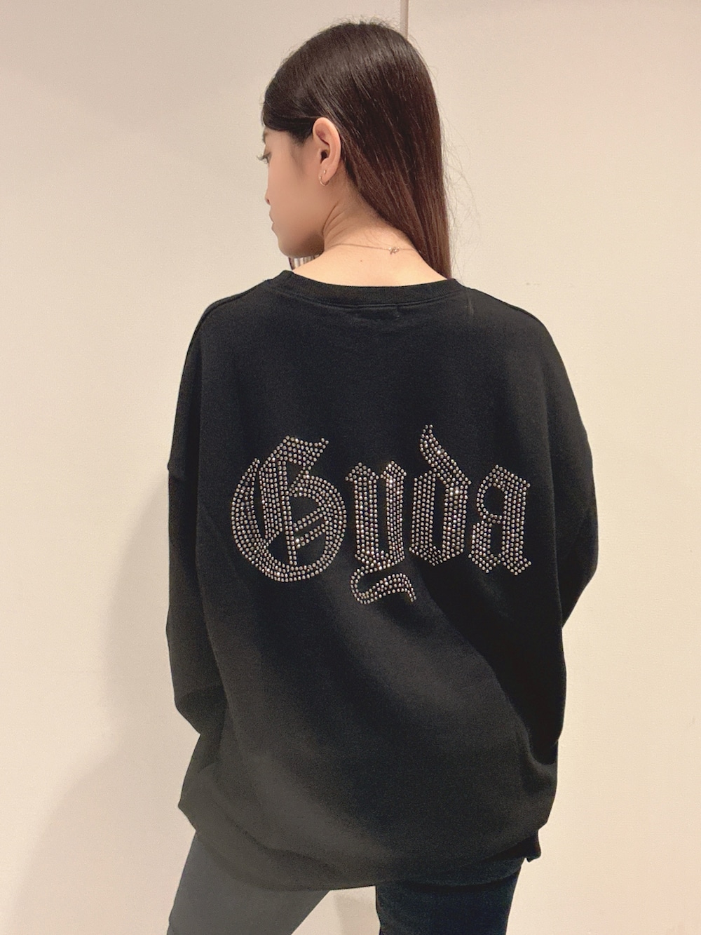 ブラック系のパーカー、ブルー系のデニムパンツ、ブラック系のブーツを着用したレディースの秋コーディネートの6枚目の写真