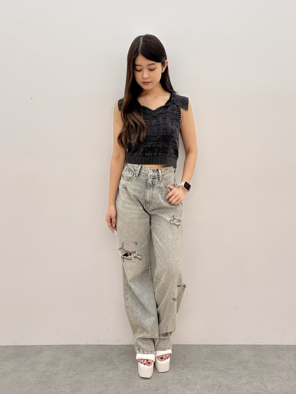 ブラック系のニット/セーター、ブルー系のデニムパンツ、ブラック系のバックパック/リュックを着用したレディースの夏コーディネートの2枚目の写真