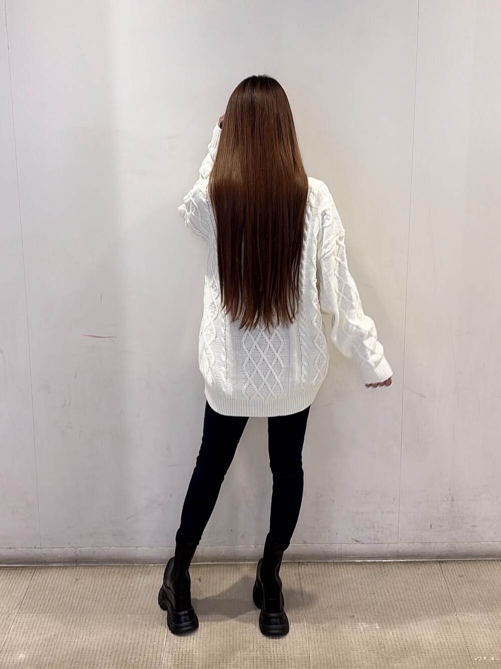 ホワイト系のニット/セーター、ブルー系のデニムパンツ、ブラック系のブーツを着用したレディースの秋コーディネートの4枚目の写真