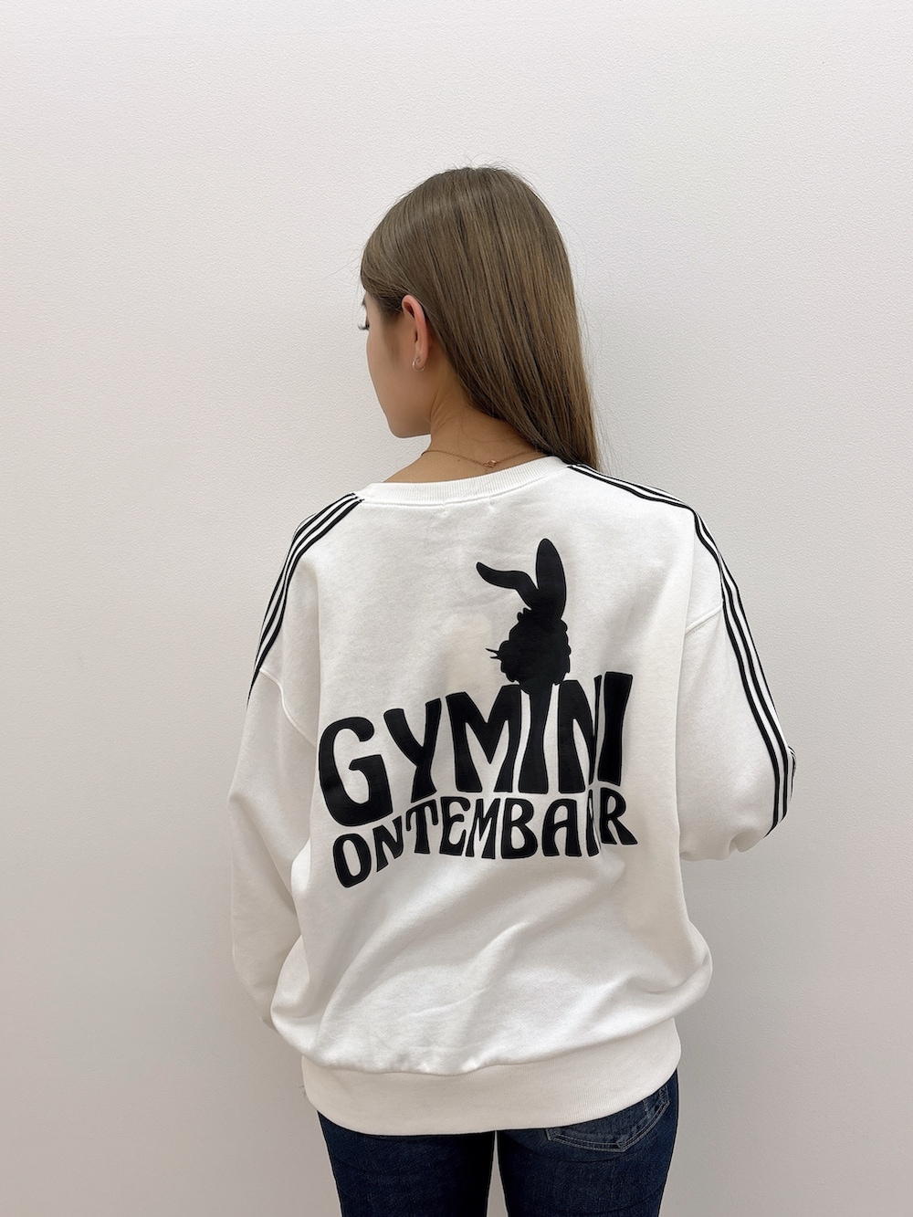 ホワイト系のスウェット、ブルー系のデニムパンツ、ブラック系のブーツを着用したレディースの冬コーディネートの5枚目の写真