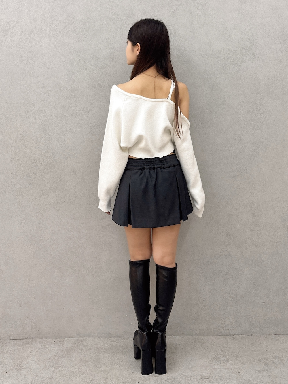 ホワイト系のニット/セーター、ブラック系のスカート、ブラック系のブーツを着用したレディースの秋コーディネートの4枚目の写真