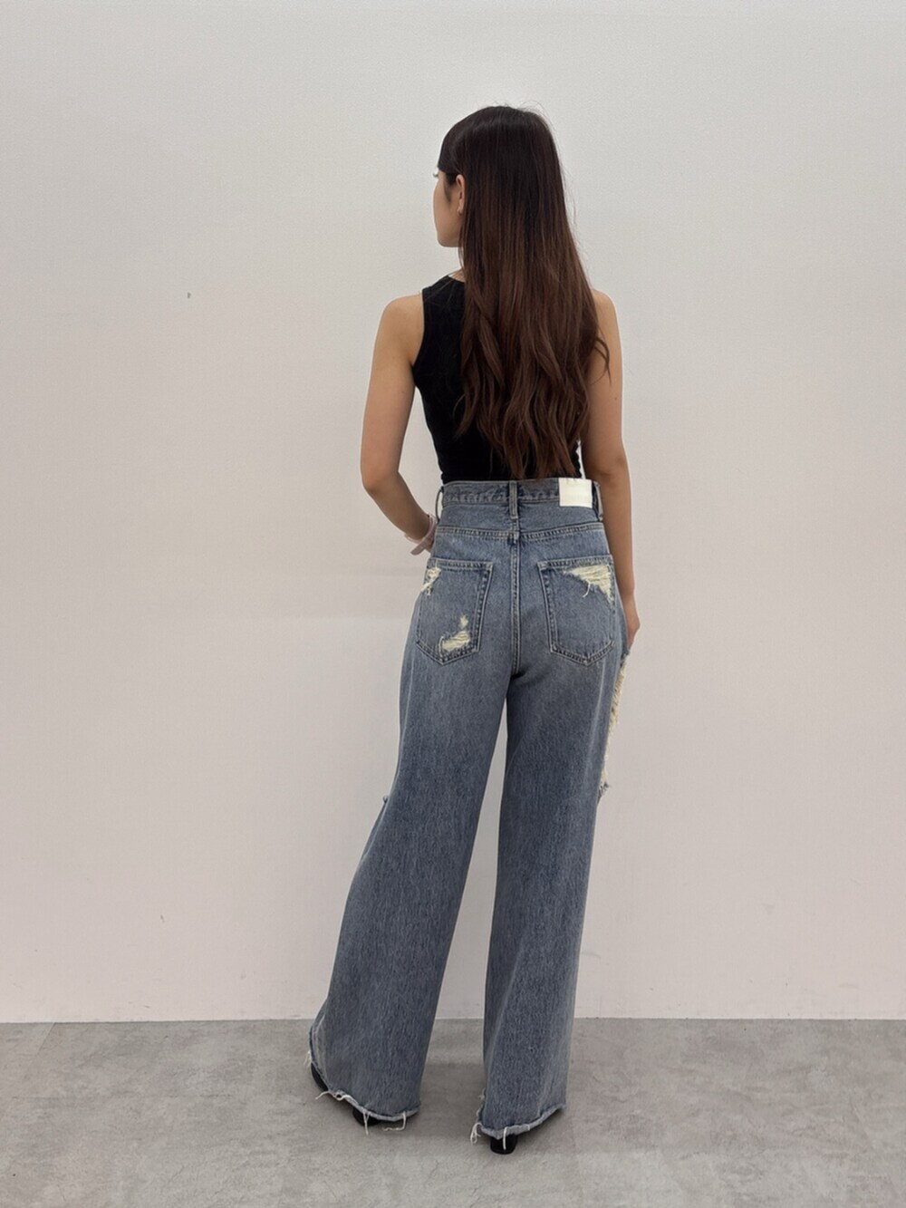 ブラック系のサンダル、ブルー系のデニムパンツ、ブラック系のタンクトップを着用したレディースの夏コーディネートの3枚目の写真