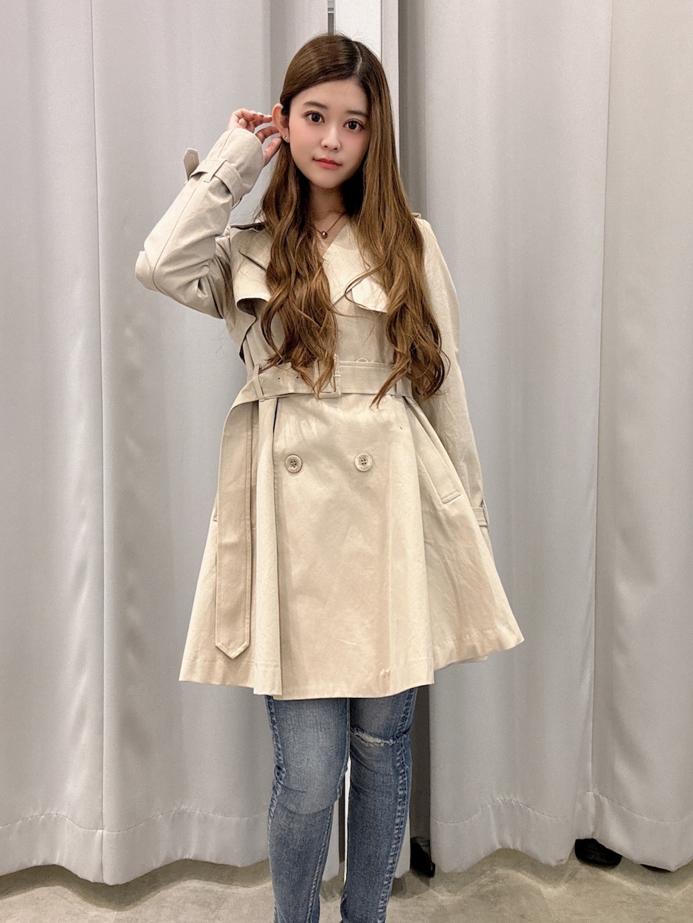 ベージュ系のトレンチコート、ブルー系のデニムパンツ、ホワイト系のパンプスを着用したレディースの春コーディネートの4枚目の写真