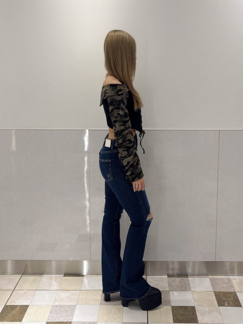 ブルー系のデニムパンツ、ブラック系のブーツ、グリーン系のTシャツ/カットソーを着用したレディースの秋コーディネートの2枚目の写真