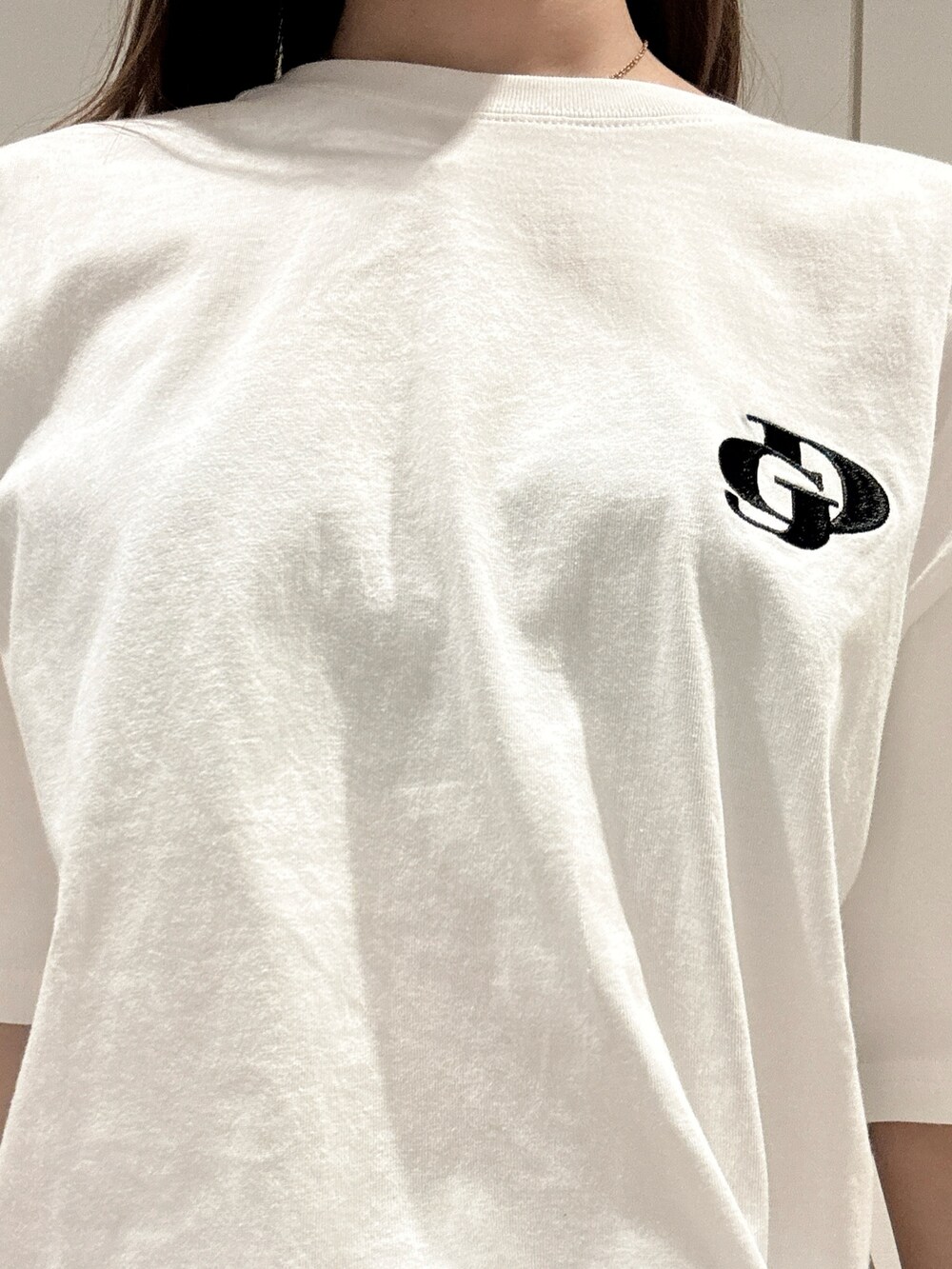 ホワイト系のTシャツ/カットソー、ブルー系のデニムパンツ、ブラック系のパンプスを着用したレディースの春コーディネートの7枚目の写真