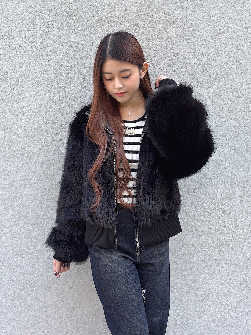 ブラック系のその他アウター、その他のニット/セーター、ブルー系のデニムパンツを着用したレディースの冬コーディネートの4枚目の写真