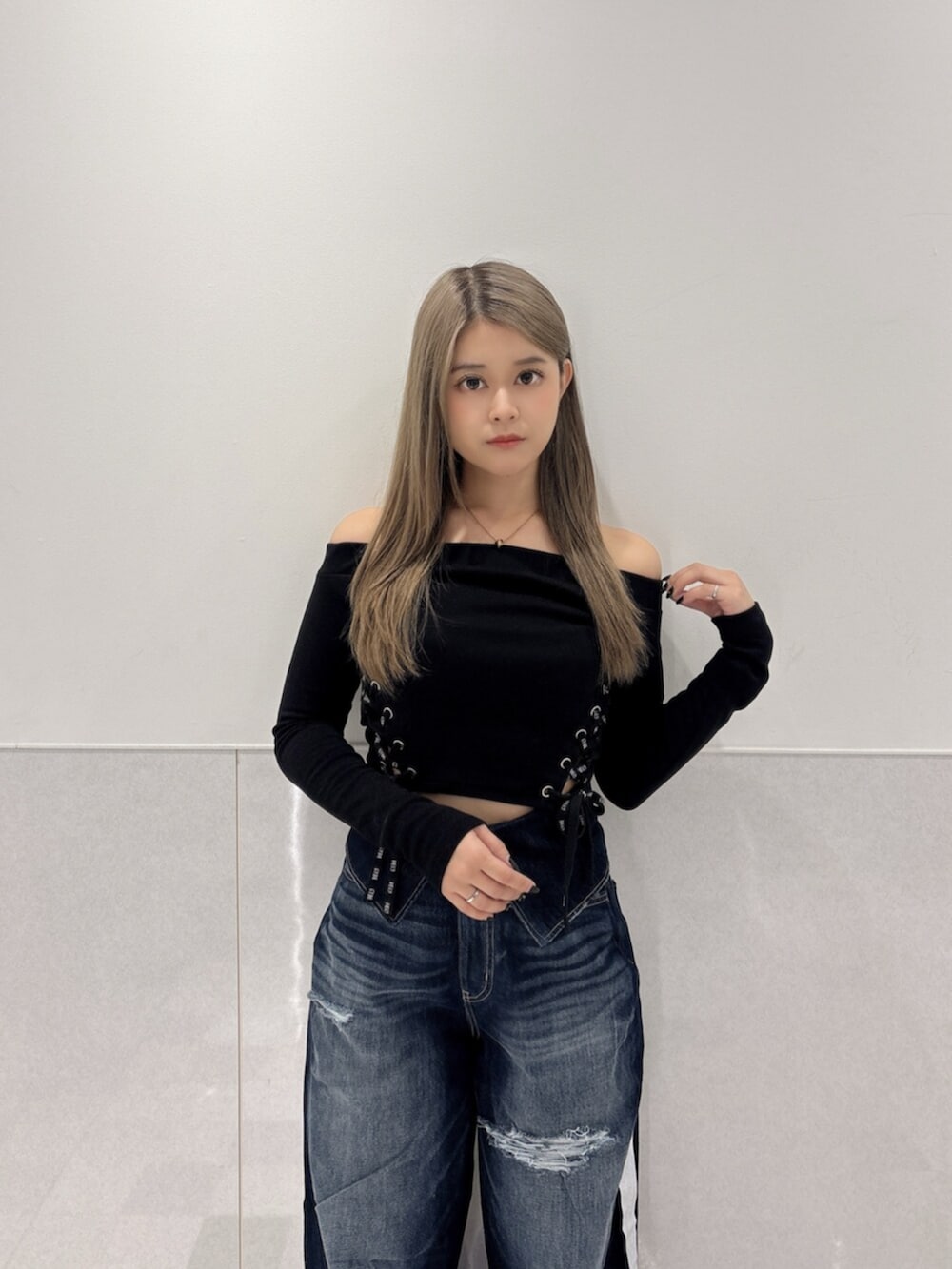 ブルー系のデニムパンツ、ブラック系のスニーカー、ブラック系のTシャツ/カットソーを着用したレディースの秋コーディネートの4枚目の写真