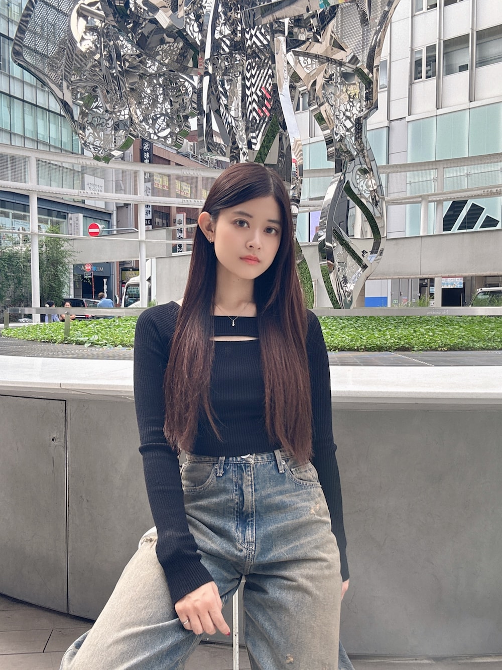 ブラック系のニット/セーター、ブルー系のデニムパンツ、ブラック系のスニーカーを着用したレディースの秋コーディネートの4枚目の写真