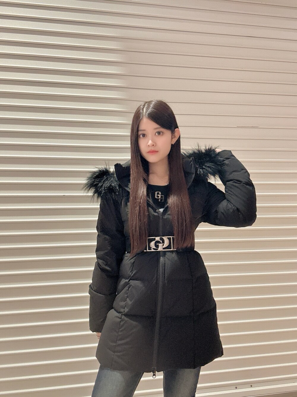 ブラック系のニット/セーター、ブラック系のダウンジャケット/コート、ブルー系のデニムパンツを着用したレディースの秋コーディネートの5枚目の写真