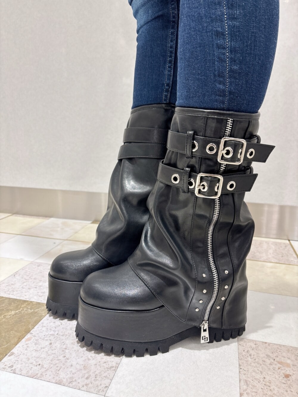ブルー系のデニムパンツ、ブラック系のキャミソール、ブラック系のブーツを着用したレディースの夏コーディネートの6枚目の写真