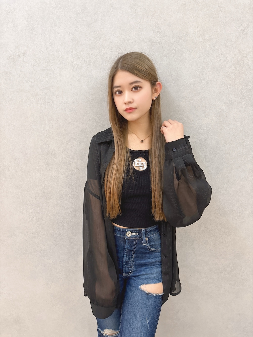 ブラック系のシャツ/ブラウス、ブラック系のTシャツ/カットソー、ブルー系のデニムパンツを着用したレディースの冬コーディネートの4枚目の写真