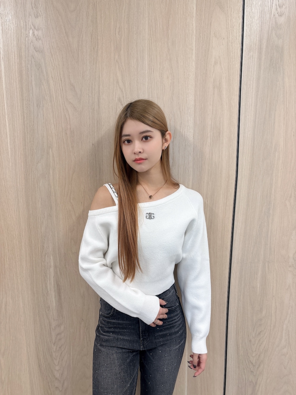 ホワイト系のニット/セーター、ブラック系のデニムパンツ、ブラック系のブーツを着用したレディースの冬コーディネートの4枚目の写真