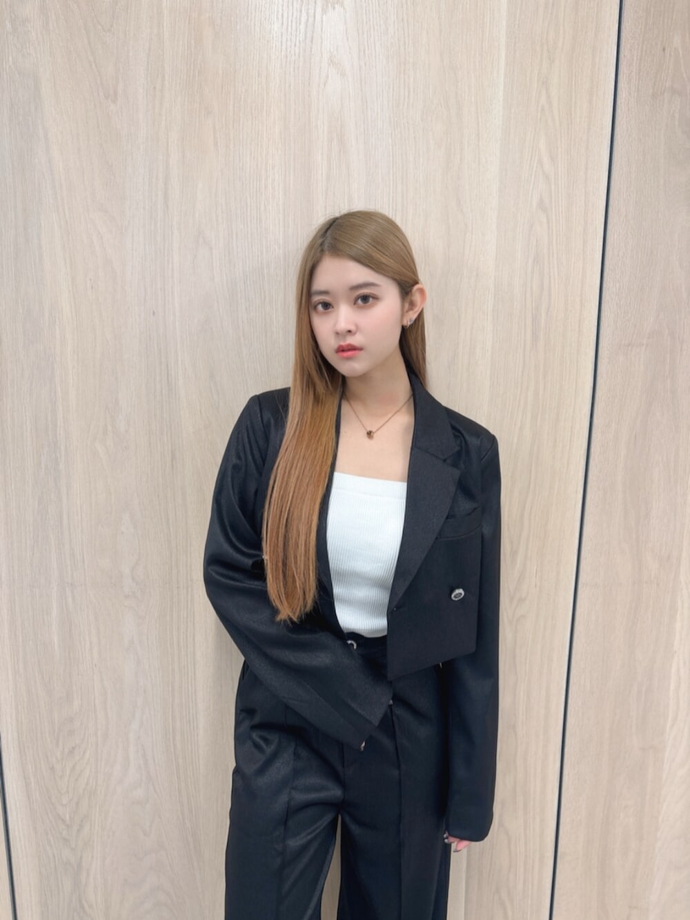 ホワイト系のキャミソール、ブラック系のテーラードジャケット、ブラック系のその他パンツを着用したレディースの春コーディネートの4枚目の写真