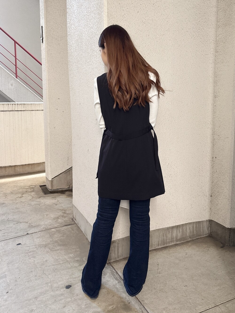 ホワイト系のTシャツ/カットソー、ブラック系のベスト、ブルー系のデニムパンツを着用したレディースの春コーディネートの3枚目の写真