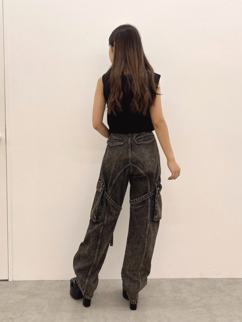 ブラック系のパーカー、ブルー系のデニムパンツ、ブラック系のサンダルを着用したレディースの夏コーディネートの3枚目の写真