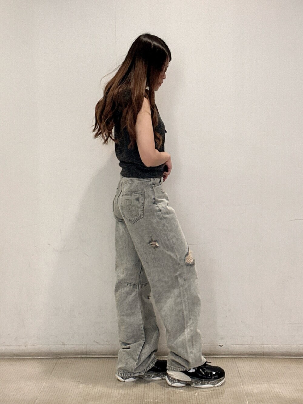 ブルー系のデニムパンツ、ブラック系のTシャツ/カットソー、ブラック系のスニーカーを着用したレディースの夏コーディネートの2枚目の写真